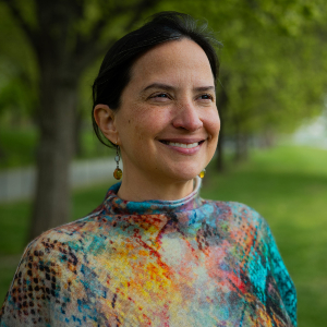 Josefina Braña Varela standing in a grassy park beneath a canopy of trees.