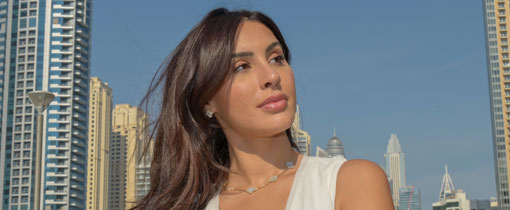Deana Uppal standing by a railing in front of many tall buildings