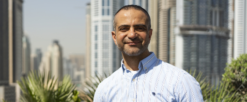 Marwan Nasry photographed against a skyline in Dubai wearing a button-up shirt and jeans.