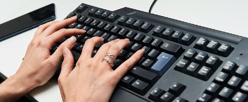 Hands typing on a mechanical keyboard