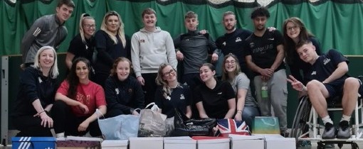 A group of students stood and seated together in casual clothing.