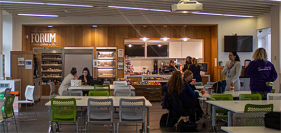 Photograph of the Forum Cafe at Wolverhampton City Campus, tables attended by groups of students.
