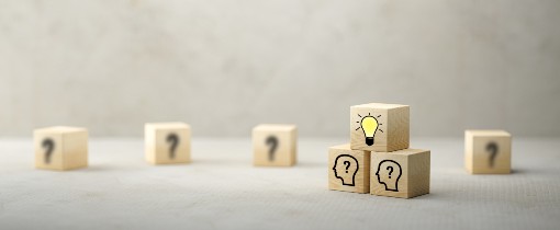 Image of small wooden cubes decorated with question marks and lightbulbs