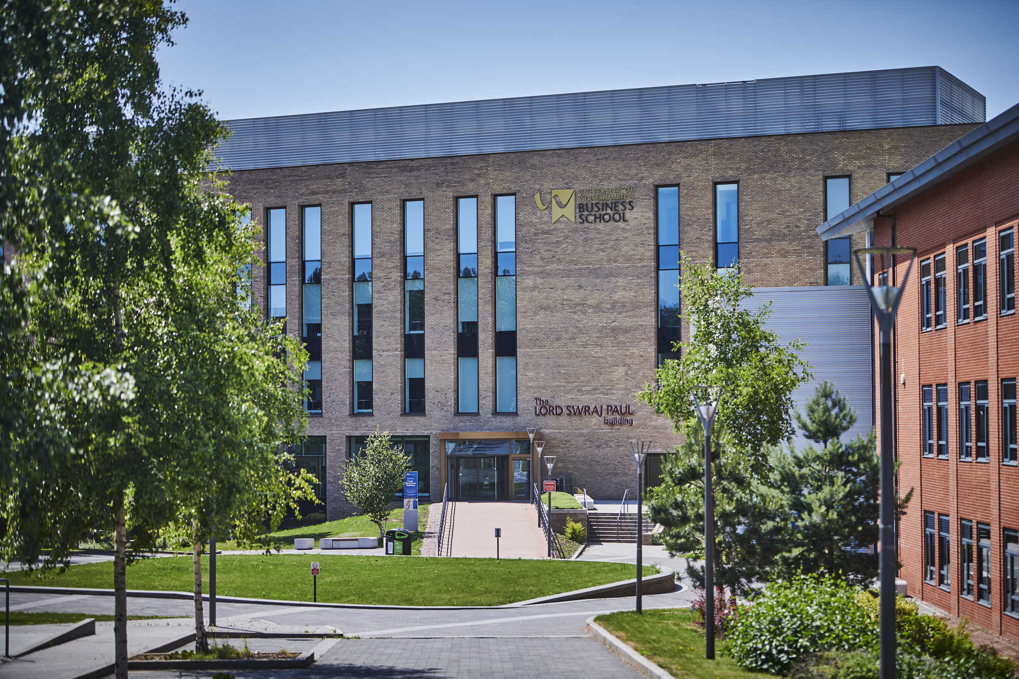 Photo of the outside of the business school including green space and entrance