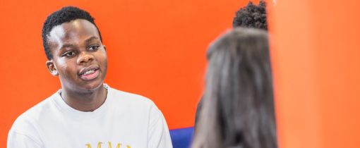 Students sitting together at table talking and smiling