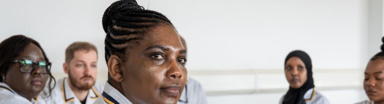 Students in uniform sitting in class and listening to lecturer