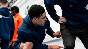 Male student checking another student's leg