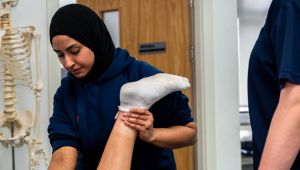 Female student lifting another student's leg up