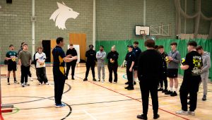 Lecturer in hall talking to students