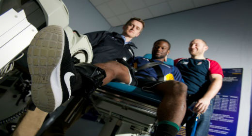 Three men inspecting exercise machines