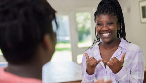 a young woman signs to someone