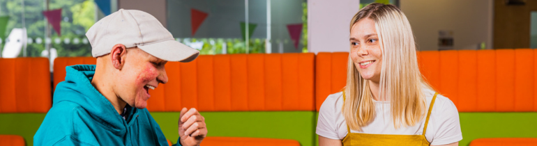 one woman signs to another who smiles