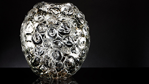 A piece of glass artwork by Allister Malcolm, round and comprised of several swirling patterns