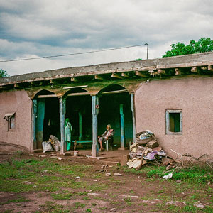 Picture of a couple sat in the veranda of a house.