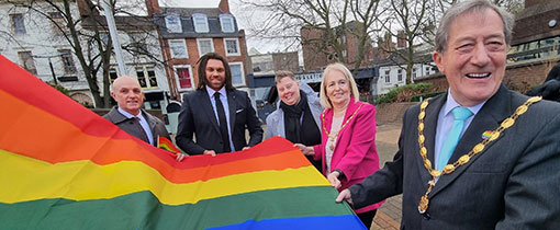 The Mayor of Wolverhampton, council officials and university staff raise the LGBT flag