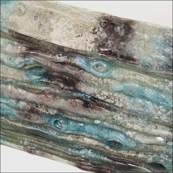 close up image of an abstract glass sculpture with white, green and purple shades