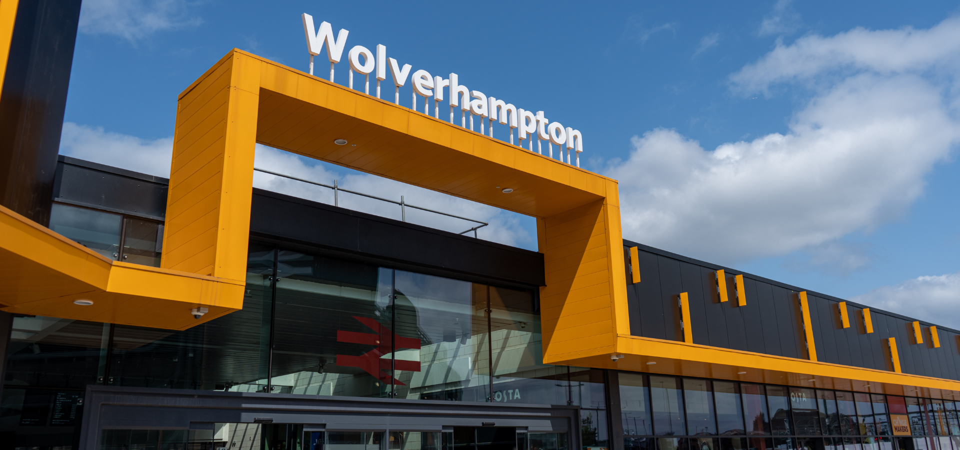 Exterior of Wolverhampton train station, displaying rail logos and the word Wolverhampton in signage