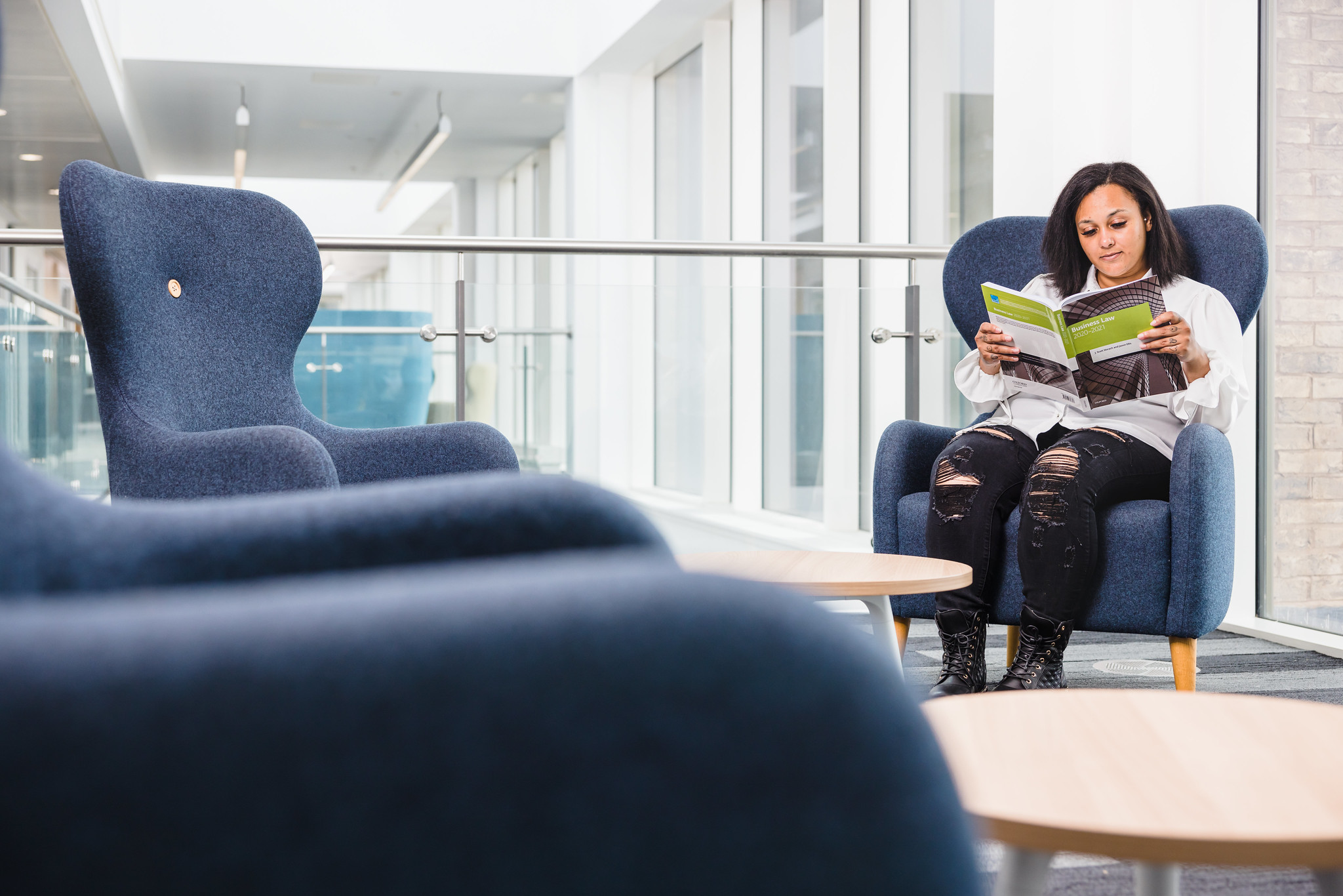 Student sat on chair reading book
