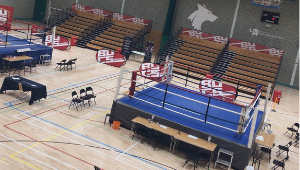 Boxing rings prepared in the University sports hall, overseen by rows of seats