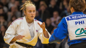 Two judo practitioners facing off, wearing white and blue judogi