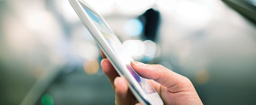 Image of a touch-screen smartphone being held and operated by the hand of a person outside the frame.