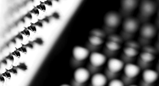 Close-up photograph of a metallic item with several rows of perforations across it.