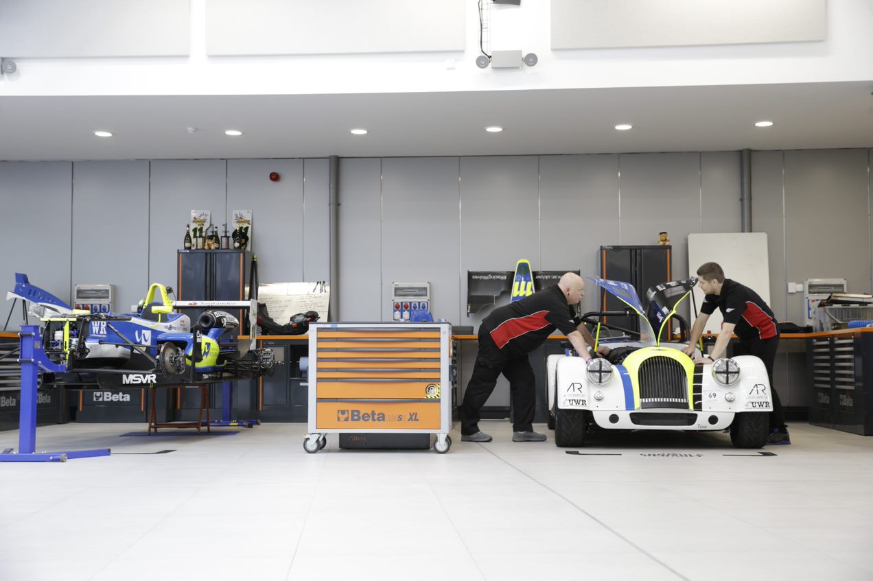 School of Engineering, Computing and Mathematical Sciences workshop, with two people working on a car