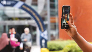 A photograph of a student taking a selfie in the University of Wolverhampton City Campus courtyard