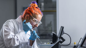 A photograph of a female student working in a chemistry lab